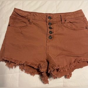 Terracotta colored cutoff denim shorts